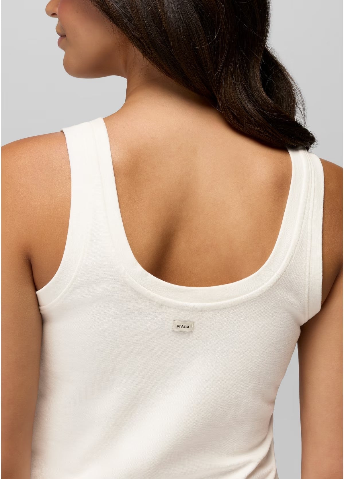White tank top worn by a person on a plain background