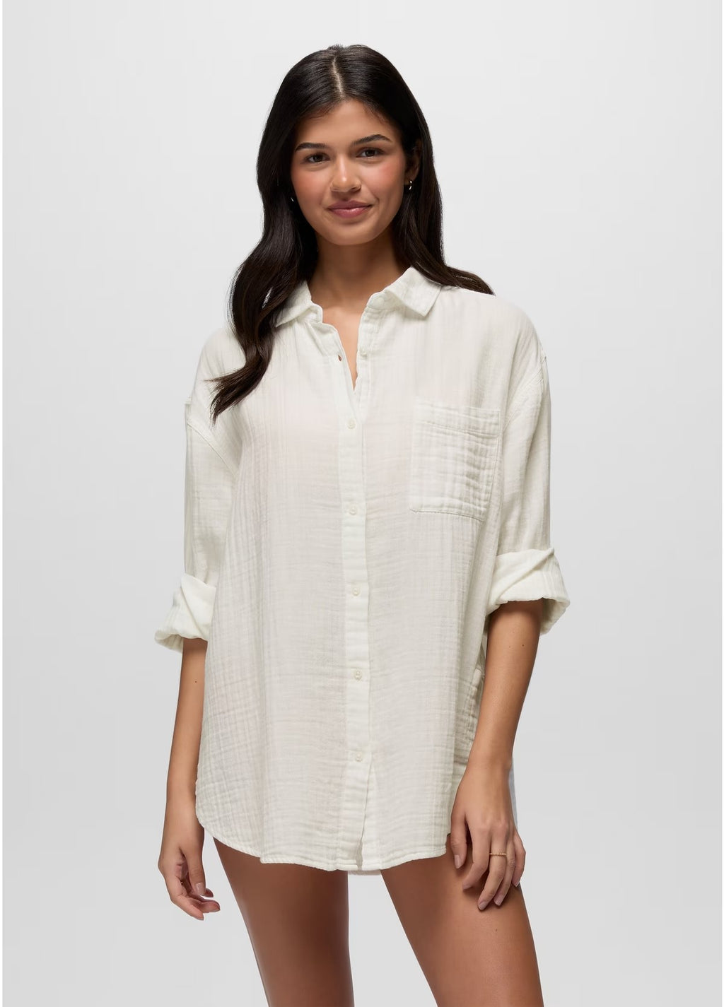 Woman wearing a white button-up shirt against a plain background