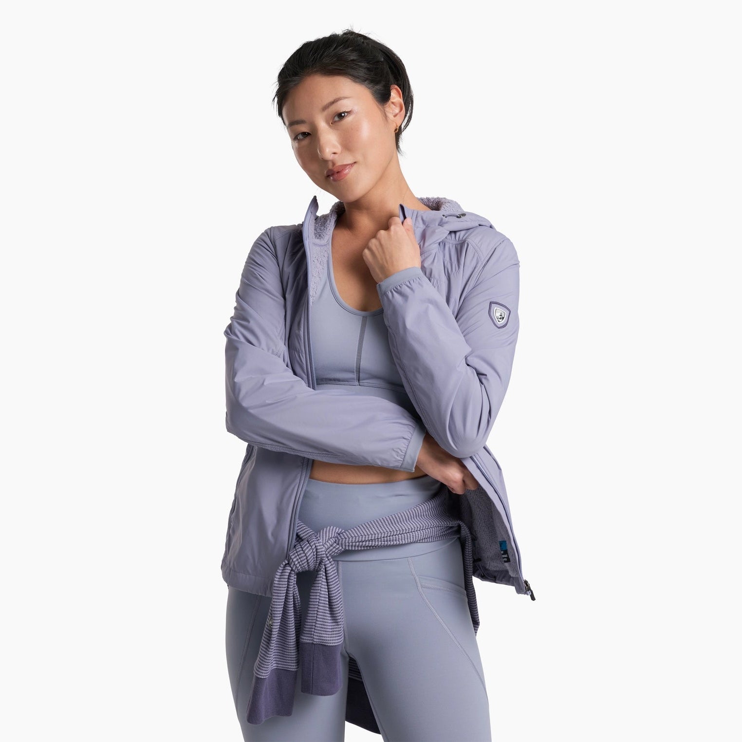 Woman wearing a light purple athletic outfit on a white background