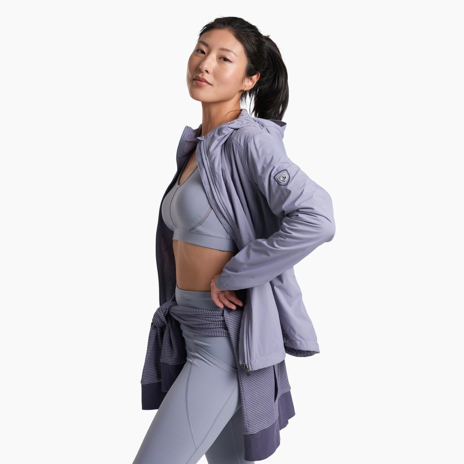 Woman wearing a light purple outfit with a matching jacket on a white background