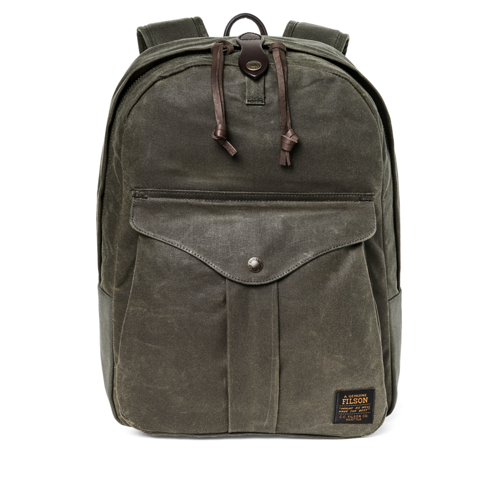 An olive green waxed canvas backpack with dark brown leather accents, including drawstrings and a small brand patch on the lower right front pocket, shown against a plain white background.
