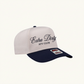 A baseball cap with a white crown and a navy blue visor, featuring the embroidered text 'Extra Dirty NY CLUB' on the front.