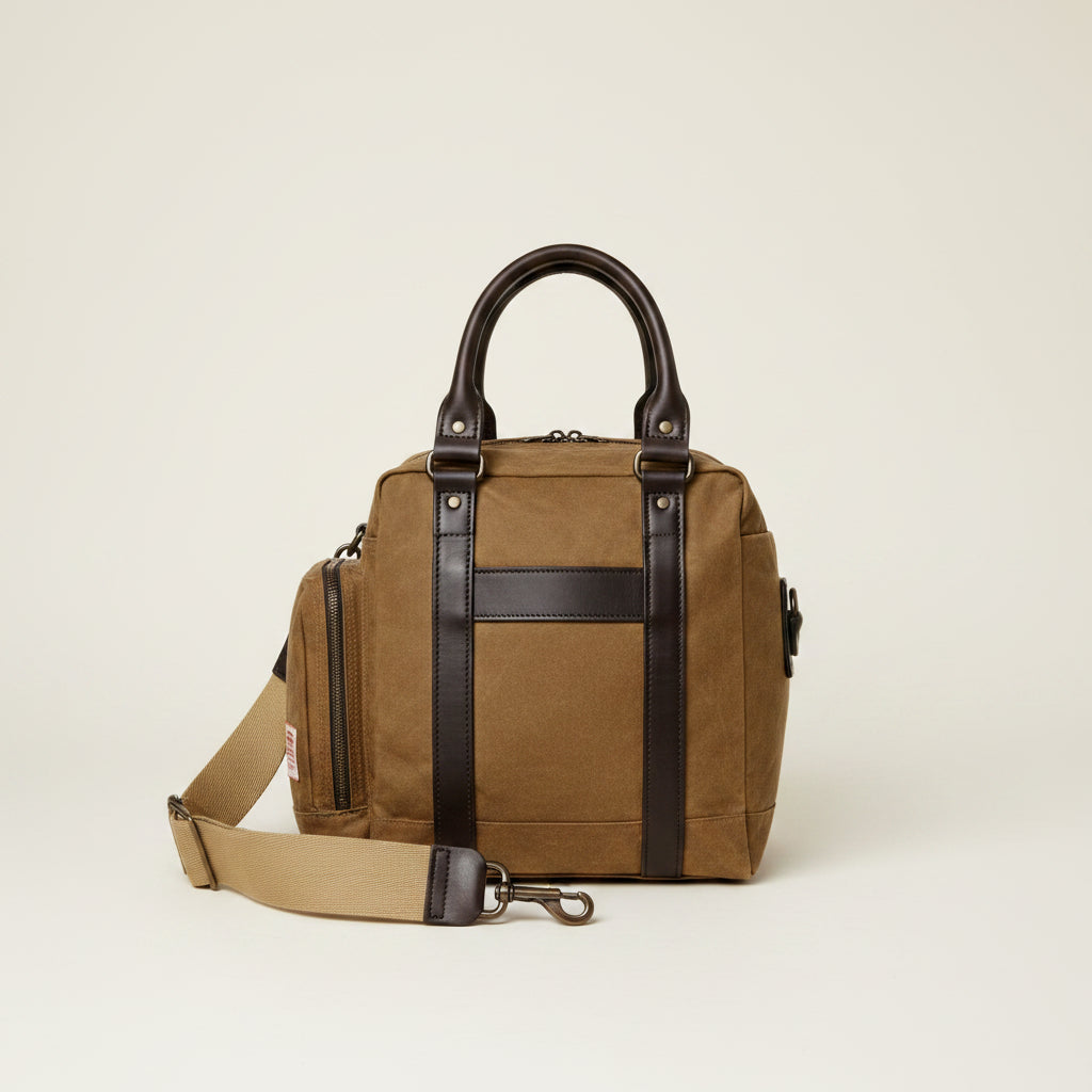 Brown duffel bag with leather straps on a white background