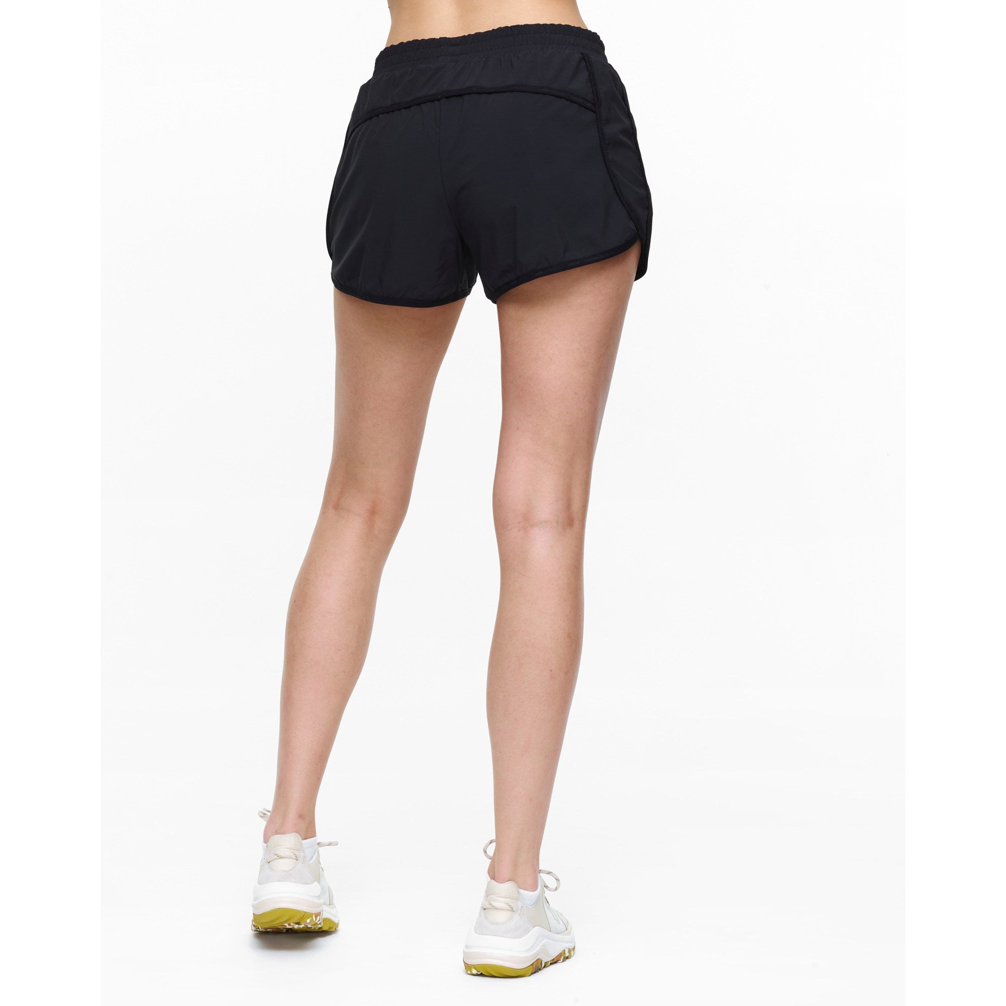 Black athletic shorts worn by a person on a white background