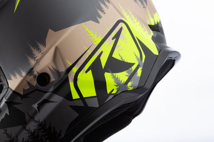Close-up of a helmet with a camouflage design featuring green and black colors on a white background.