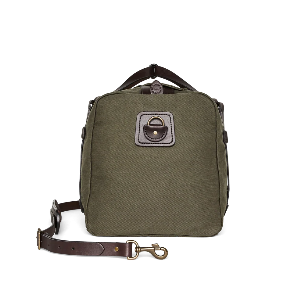 An olive green canvas shoulder bag with dark brown leather trim, a top handle, and a detachable brown leather strap with a brass snap hook, displayed on a clean white background.