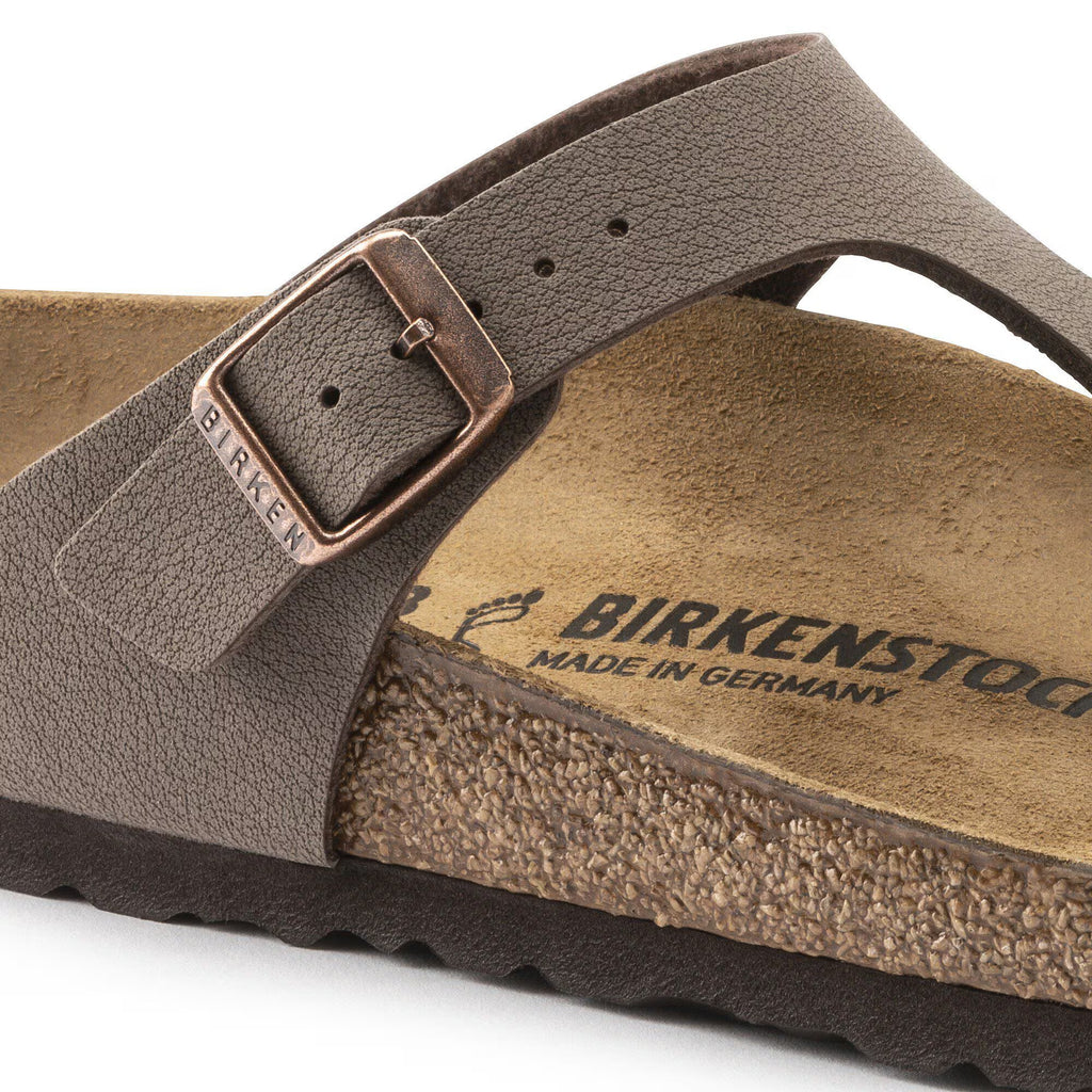 Brown Birkenstock sandal with a strap and buckle on a white background
