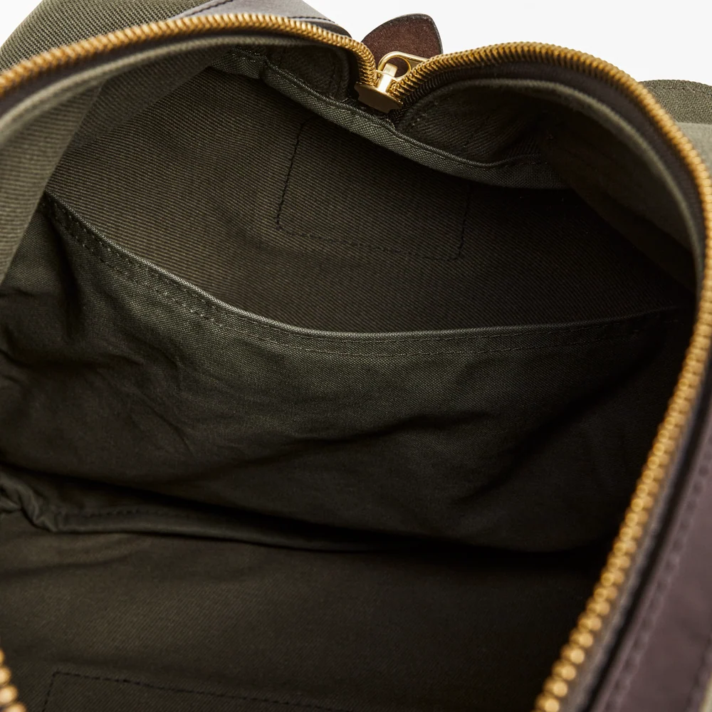 Close-up of a green backpack with a gold zipper