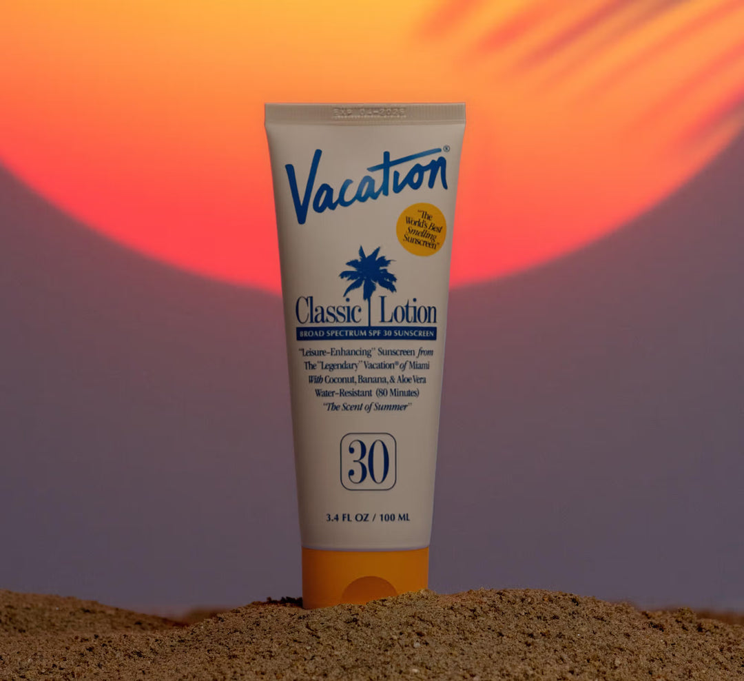 Sunscreen lotion tube labeled 'Vacation' on a sand-like textured background with a colorful gradient.
