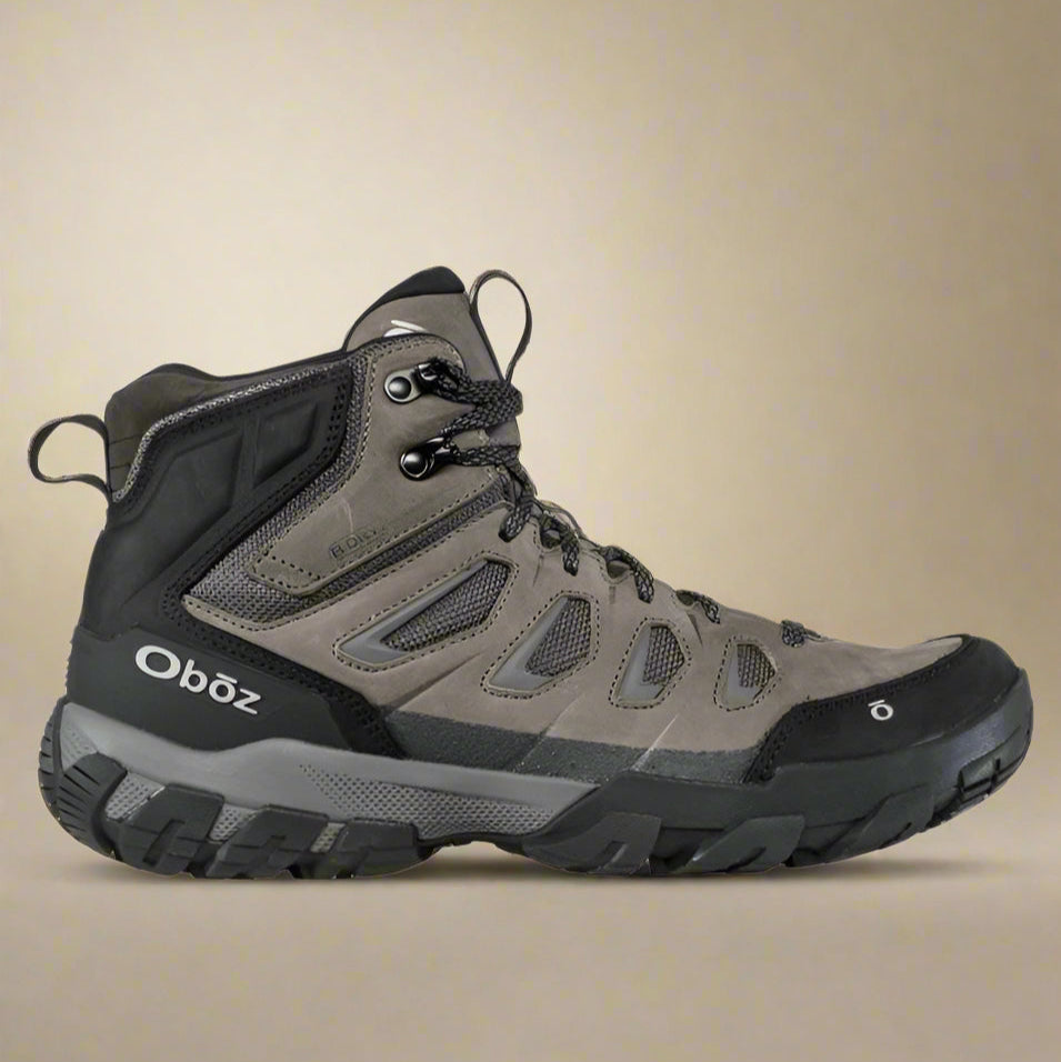 A Oboz Men's Sawtooth X Mid Waterproof boot in gray and black colors with lace-up closure, designed for hiking.