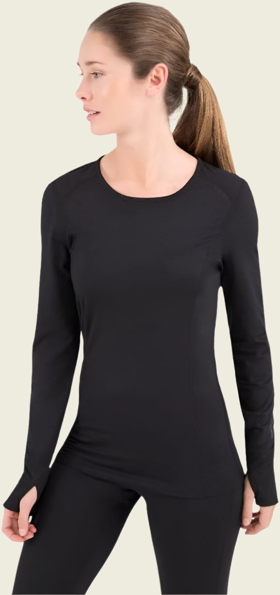 Woman wearing a black long-sleeve top and black pants on a white background