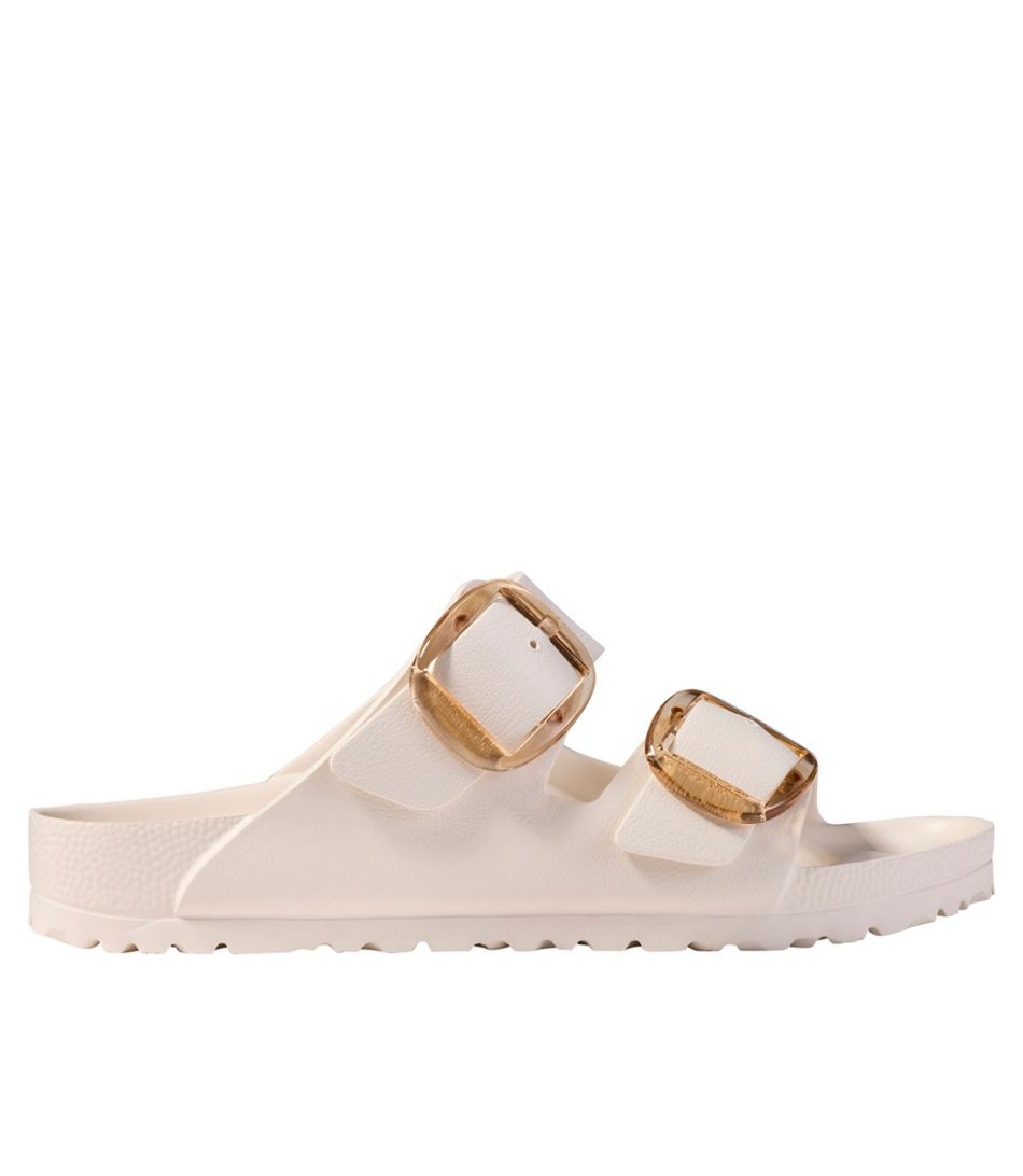 White sandal with gold buckles on a white background