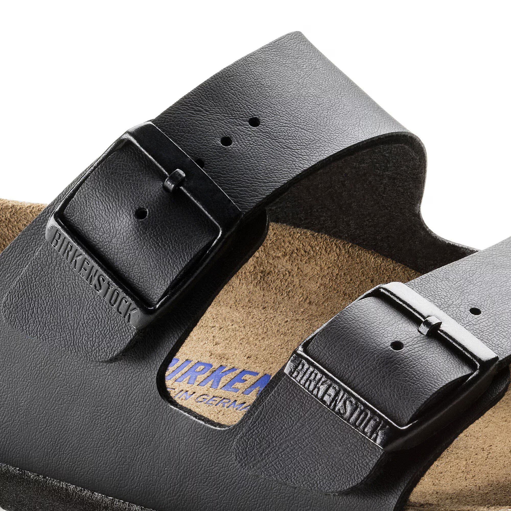 Black Birkenstock sandals with brown insole on a white background