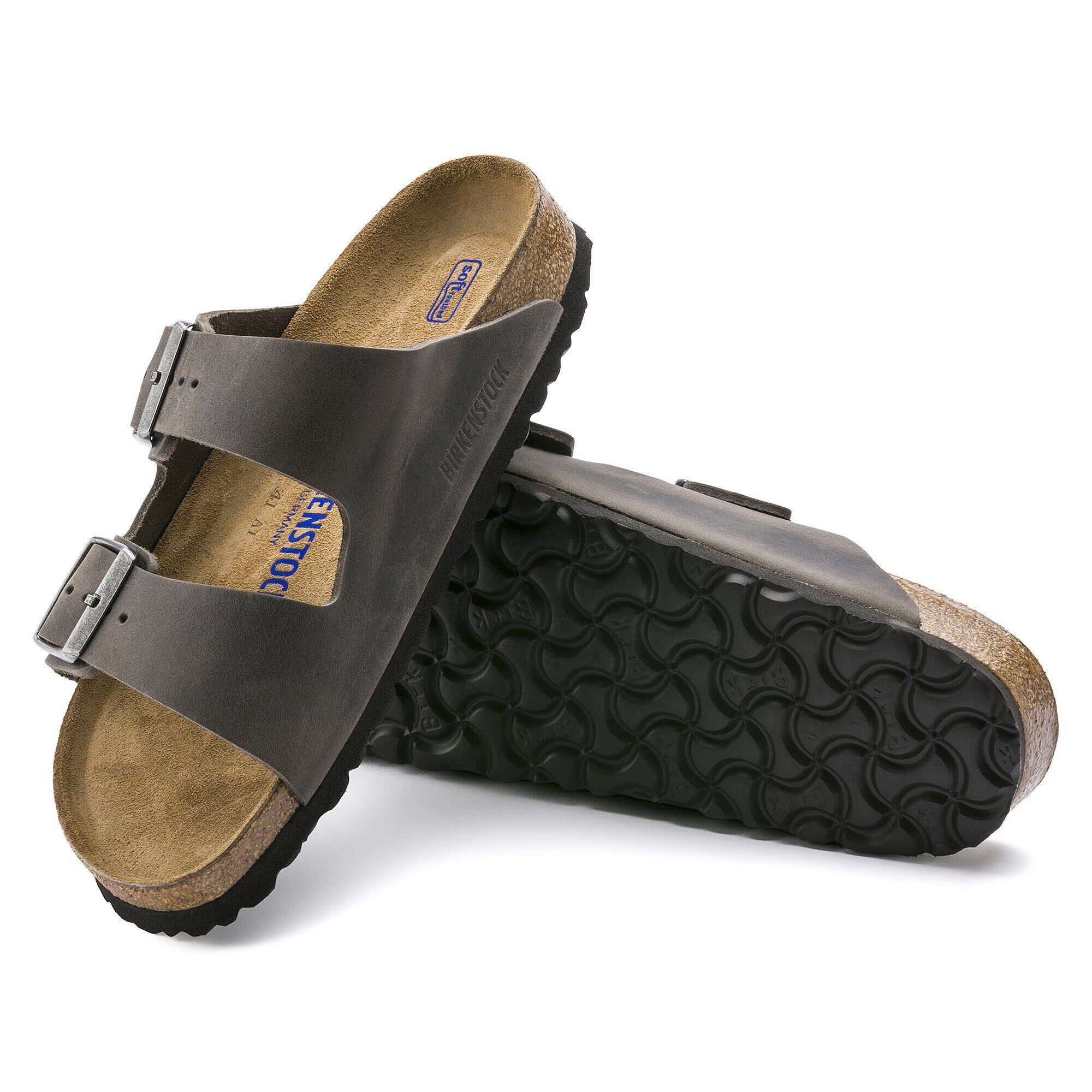 Brown sandals with black soles on a white background