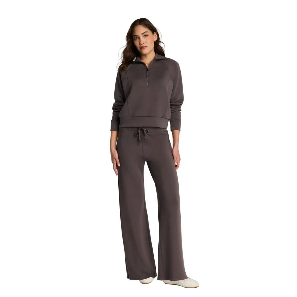 Woman wearing a brown tracksuit on a white background