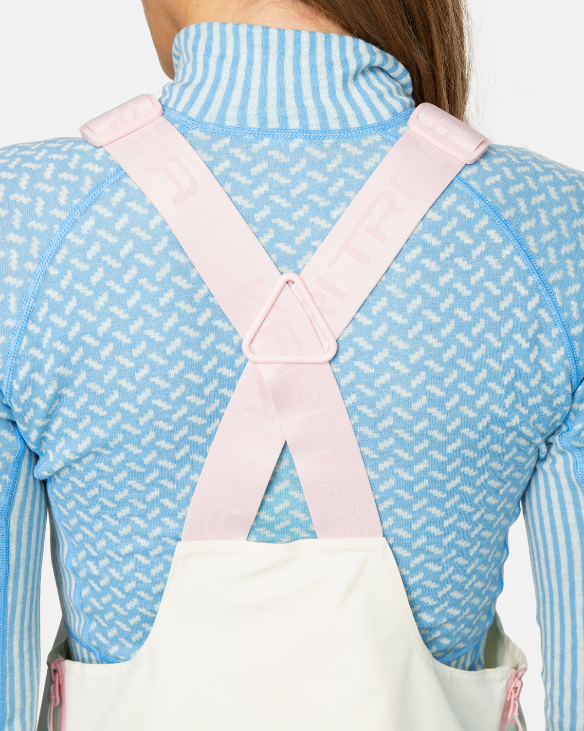 Person wearing a white apron over a blue outfit with a pink zipper.