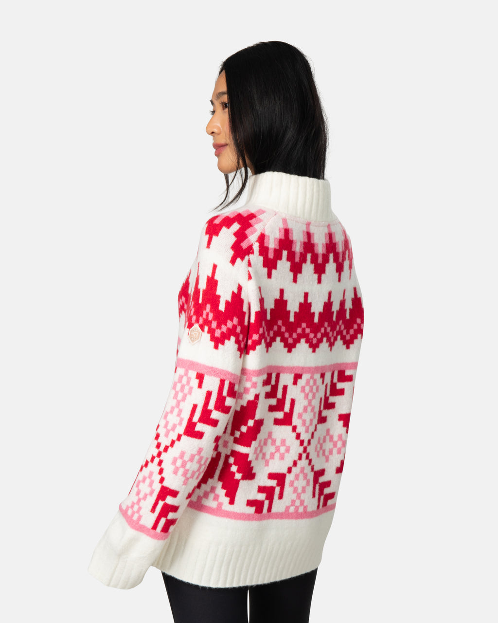 Woman wearing a white sweater with pink geometric pattern on a white background