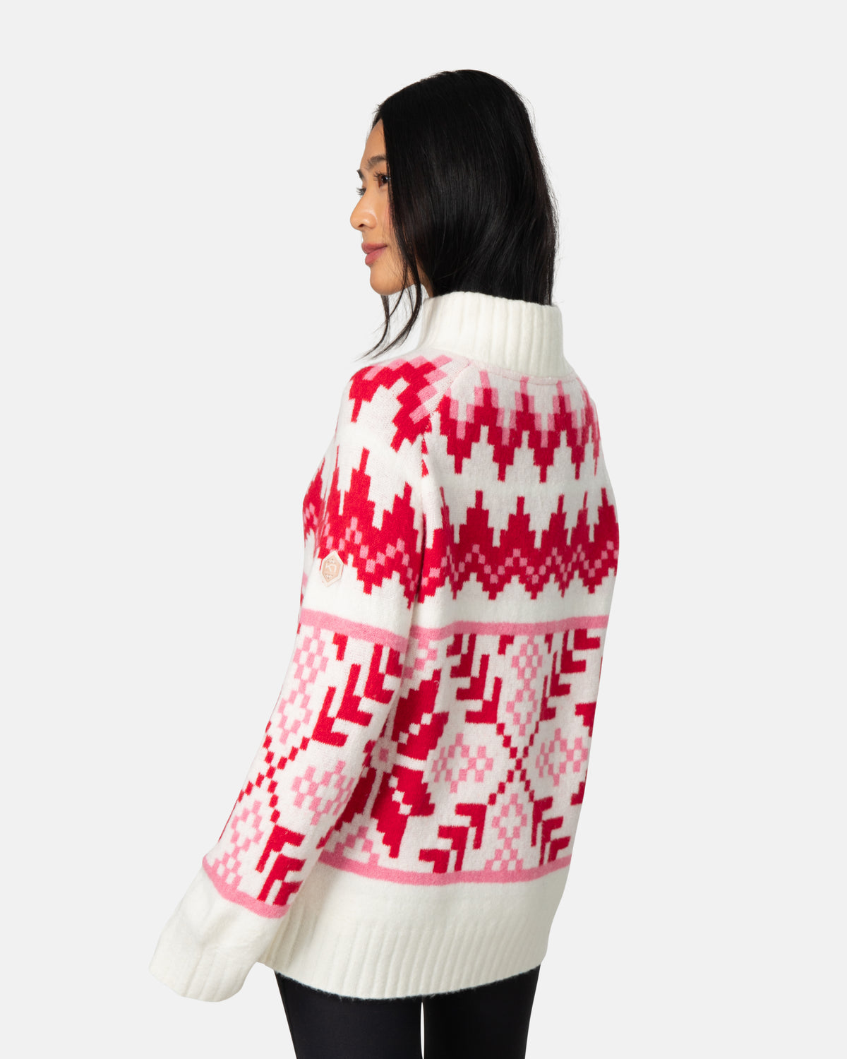 Woman wearing a white sweater with pink geometric pattern on a white background