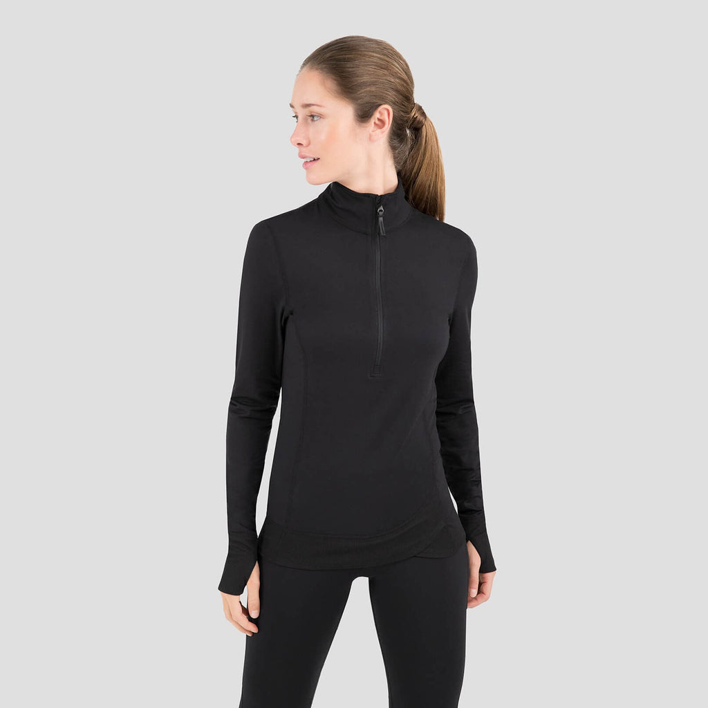 Woman wearing a black long-sleeve top with a quarter zip on a gray background