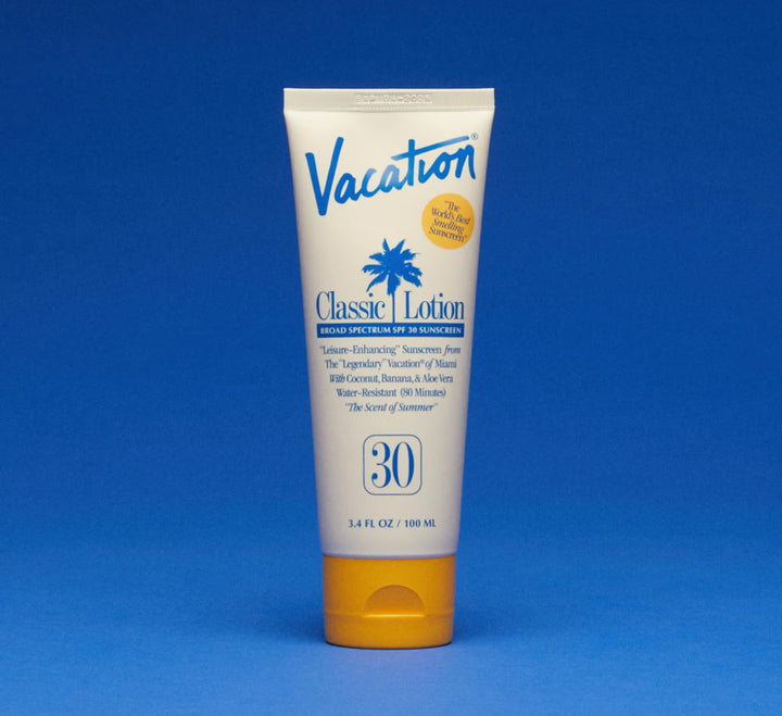 Tube of 'Vacation Classic Lotion' sunscreen on a blue background