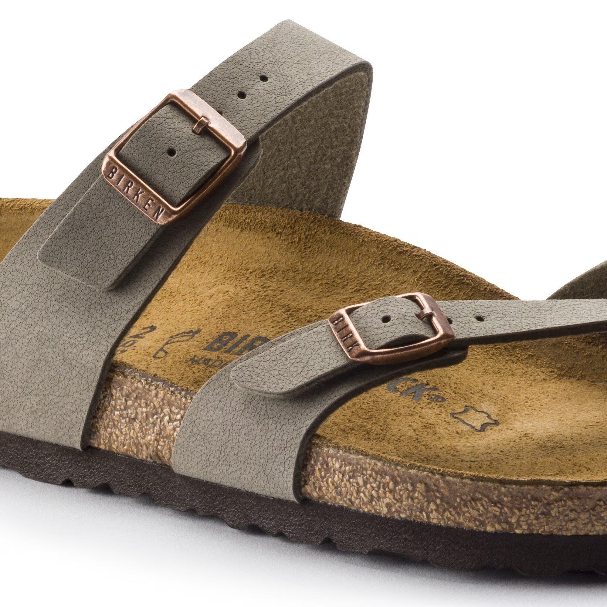 Brown sandal with a strap and buckle on a white background
