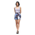 Woman wearing a sleeveless top and patterned shorts on a white background