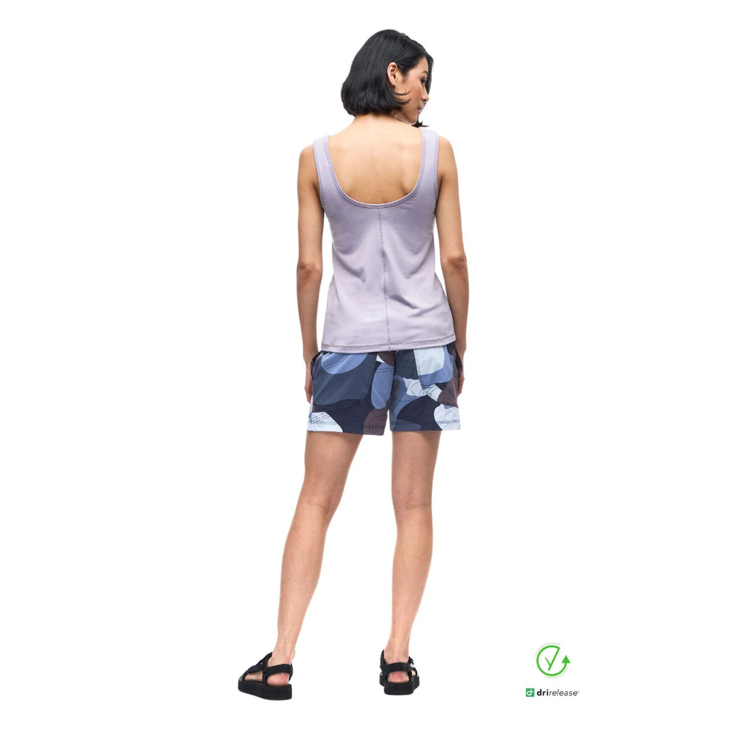 Woman wearing a light purple tank top and patterned shorts on a white background