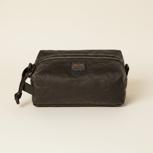 Brown waxed canvas dopp kit with Filson logo on a white background