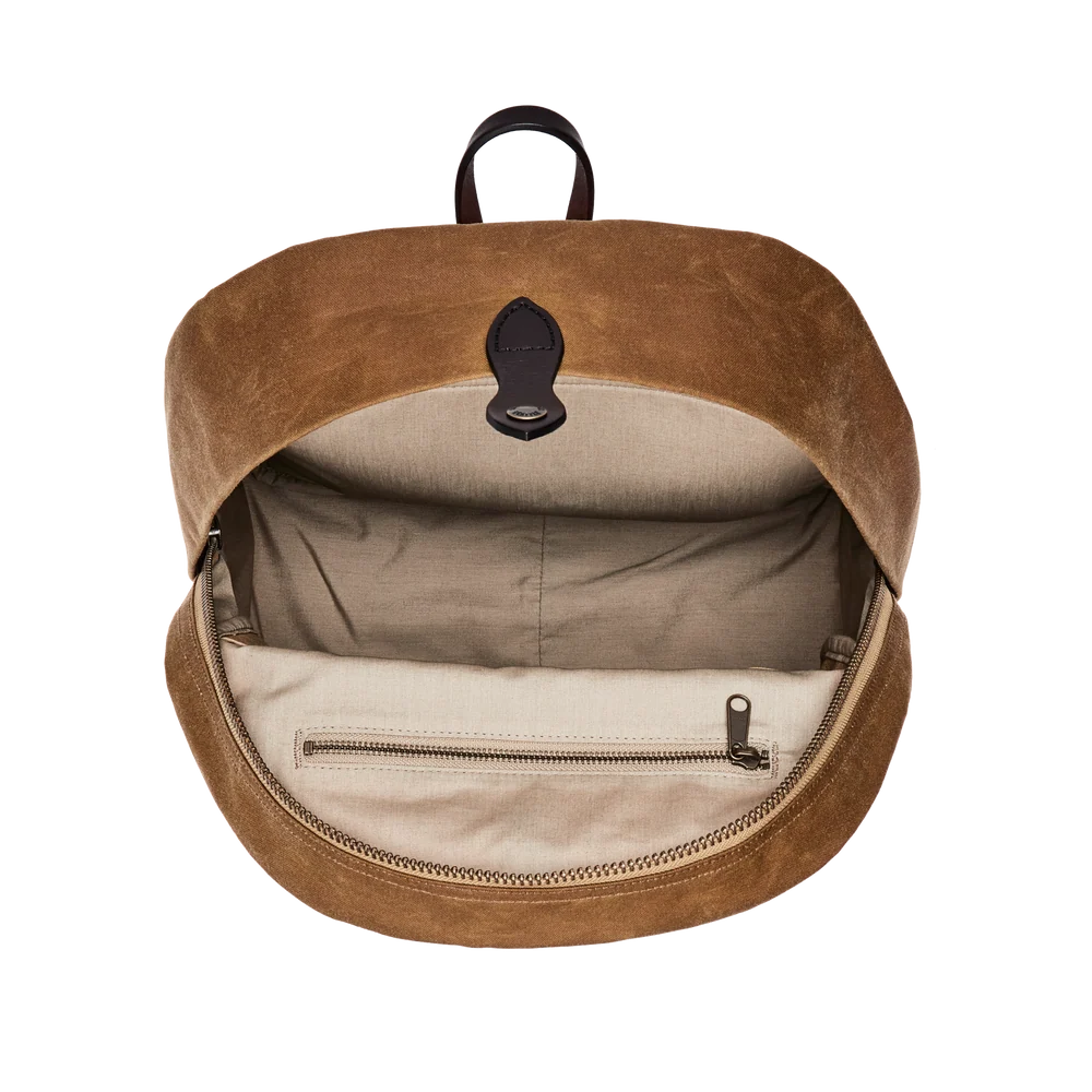 An open brown suede backpack shown from the front, revealing a beige interior lining with a zippered pocket and a black top handle, set against a plain white background.