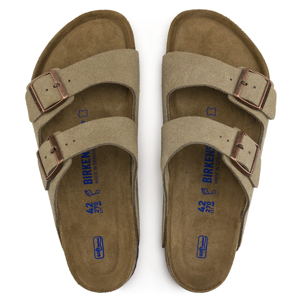 Pair of tan sandals with brown buckles on a white background