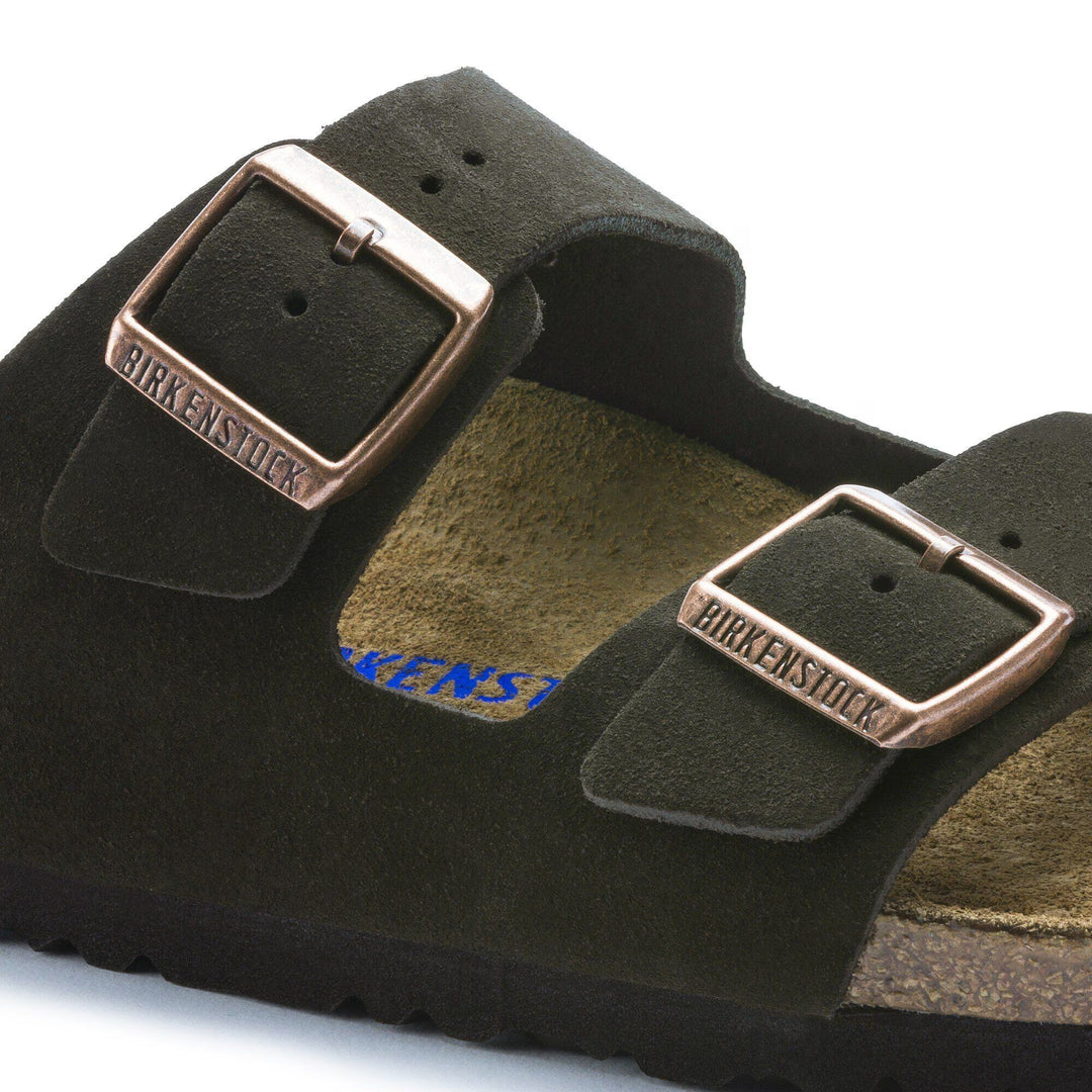 Green suede Birkenstock sandal with brown buckles on a white background