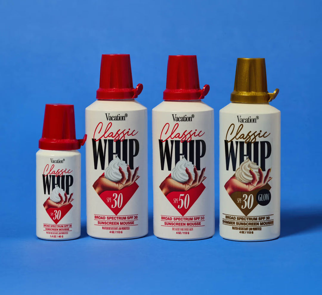 Four bottles of Classic Whip sunscreen mousse with red and gold caps on a blue background