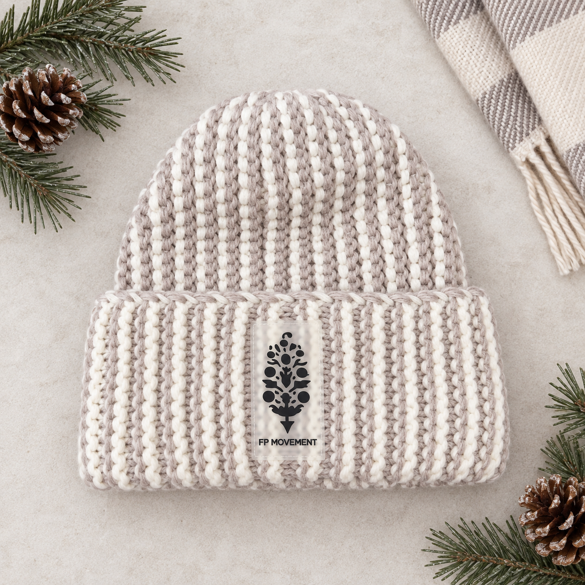 A light beige and white ribbed knit beanie hat featuring a black embroidered tree logo on the front cuff with the text 'THE TREESCHOOL' underneath.
