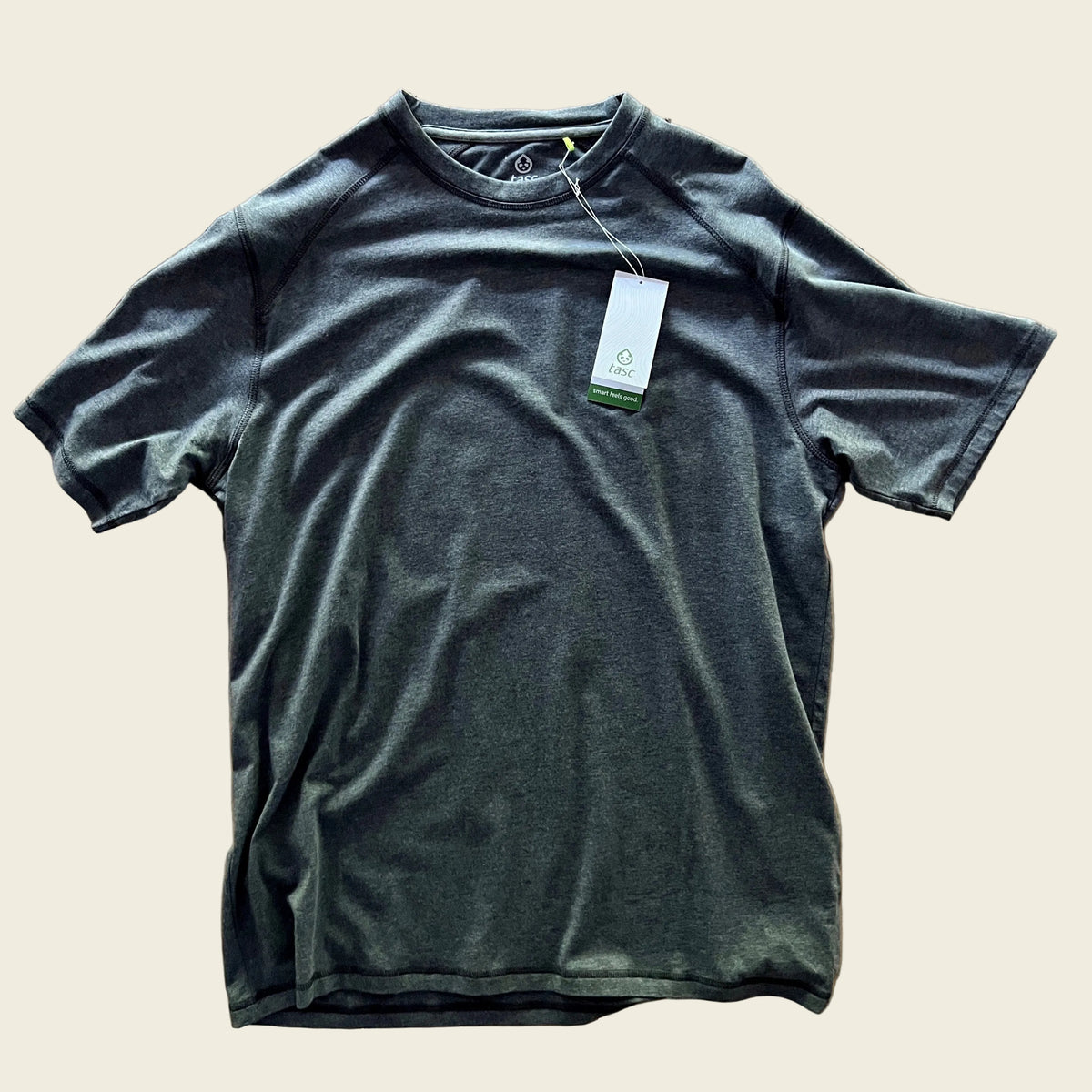 Black Heather t-shirt with a tag on a wooden surface
