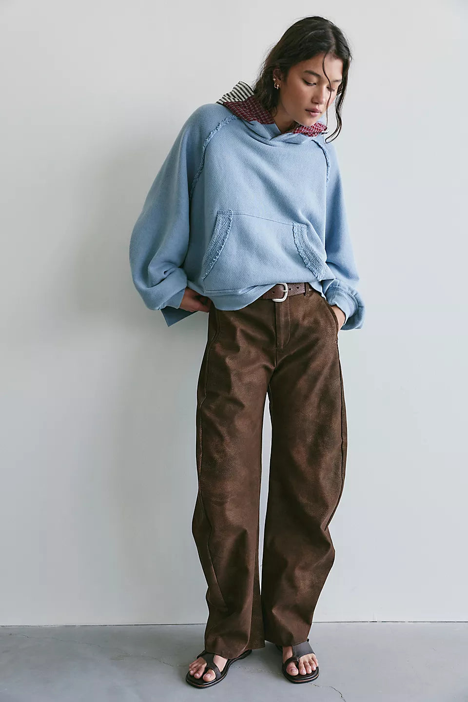 Woman modeling light blue hooded sweatshirt paired with brown pants and sandals