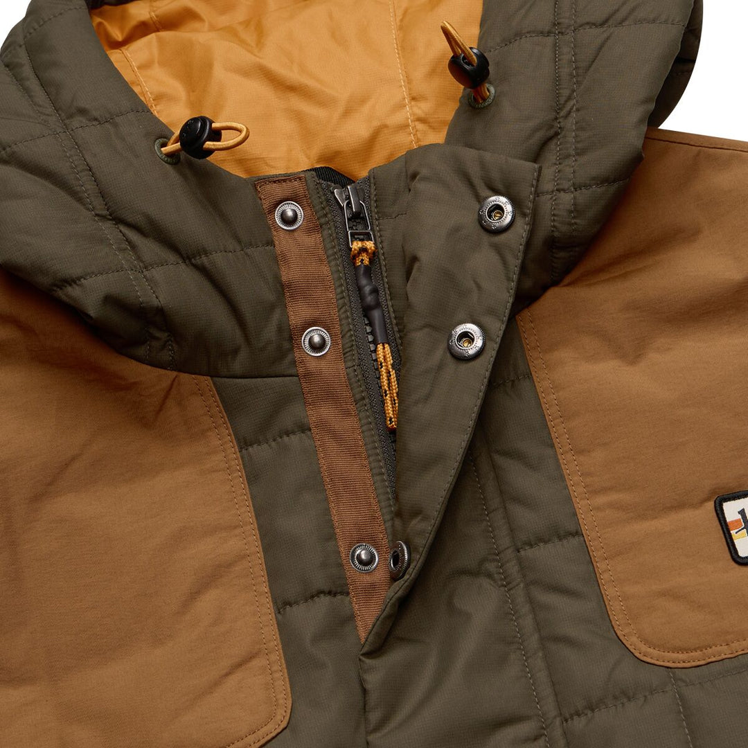 Close-up of a brown and green quilted jacket with a brand logo.