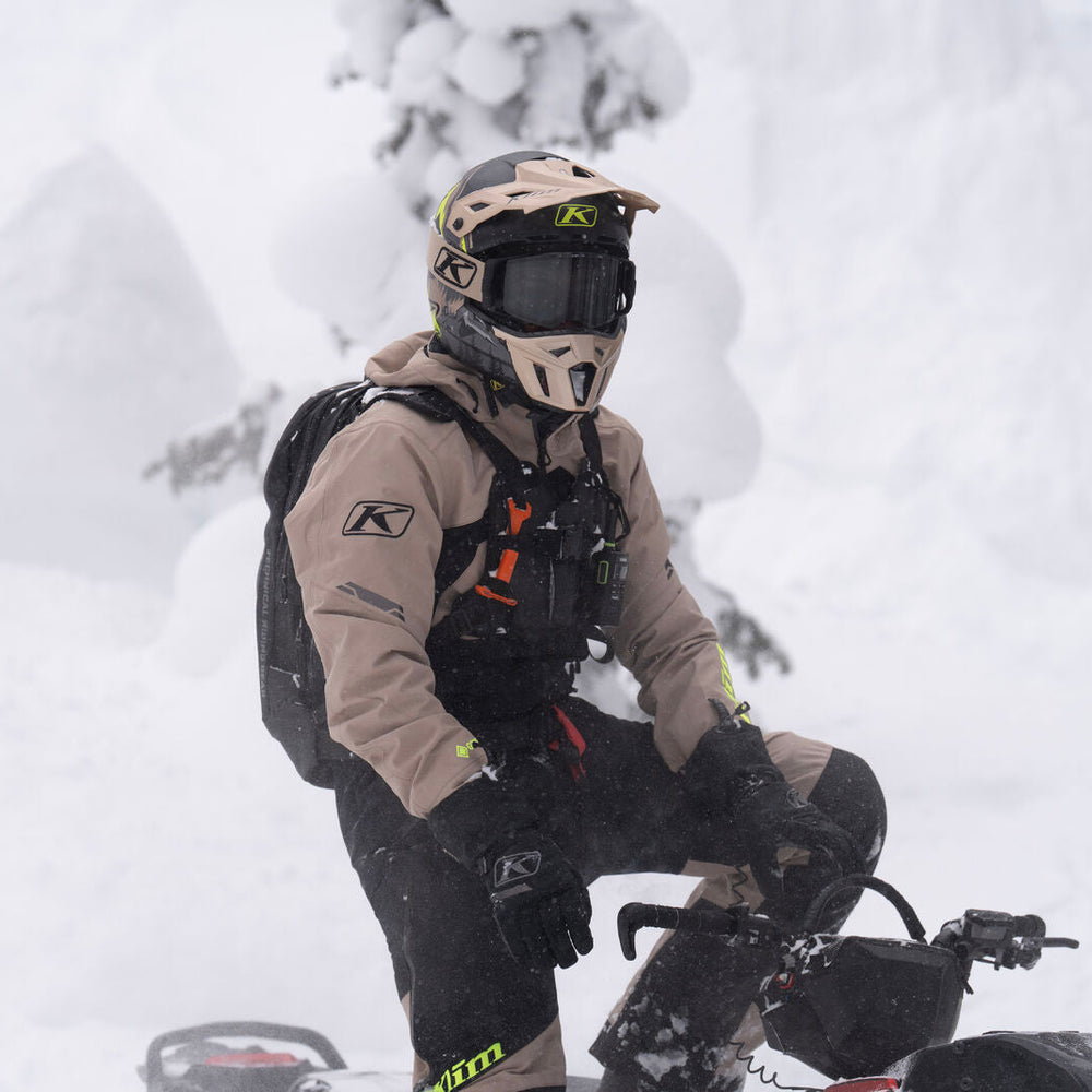 Person on a snowmobile in a snowy landscape with trees