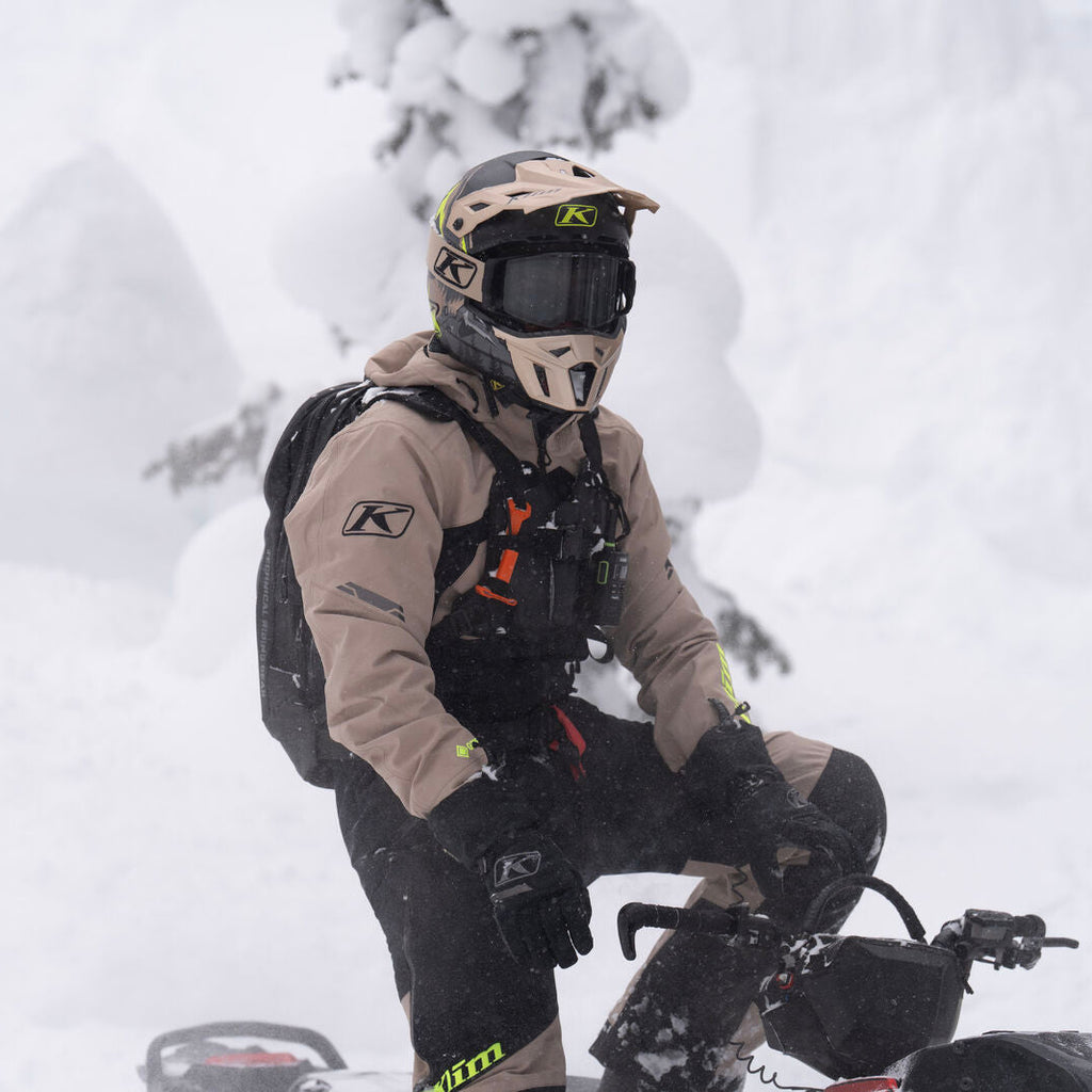 Person on a snowmobile in a snowy landscape with trees