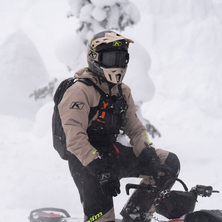 Person on a snowmobile in a snowy landscape with trees
