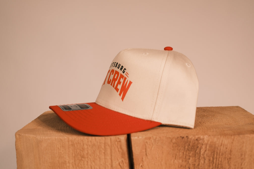 Red brim hat with Pittsburg Pit Crew on it