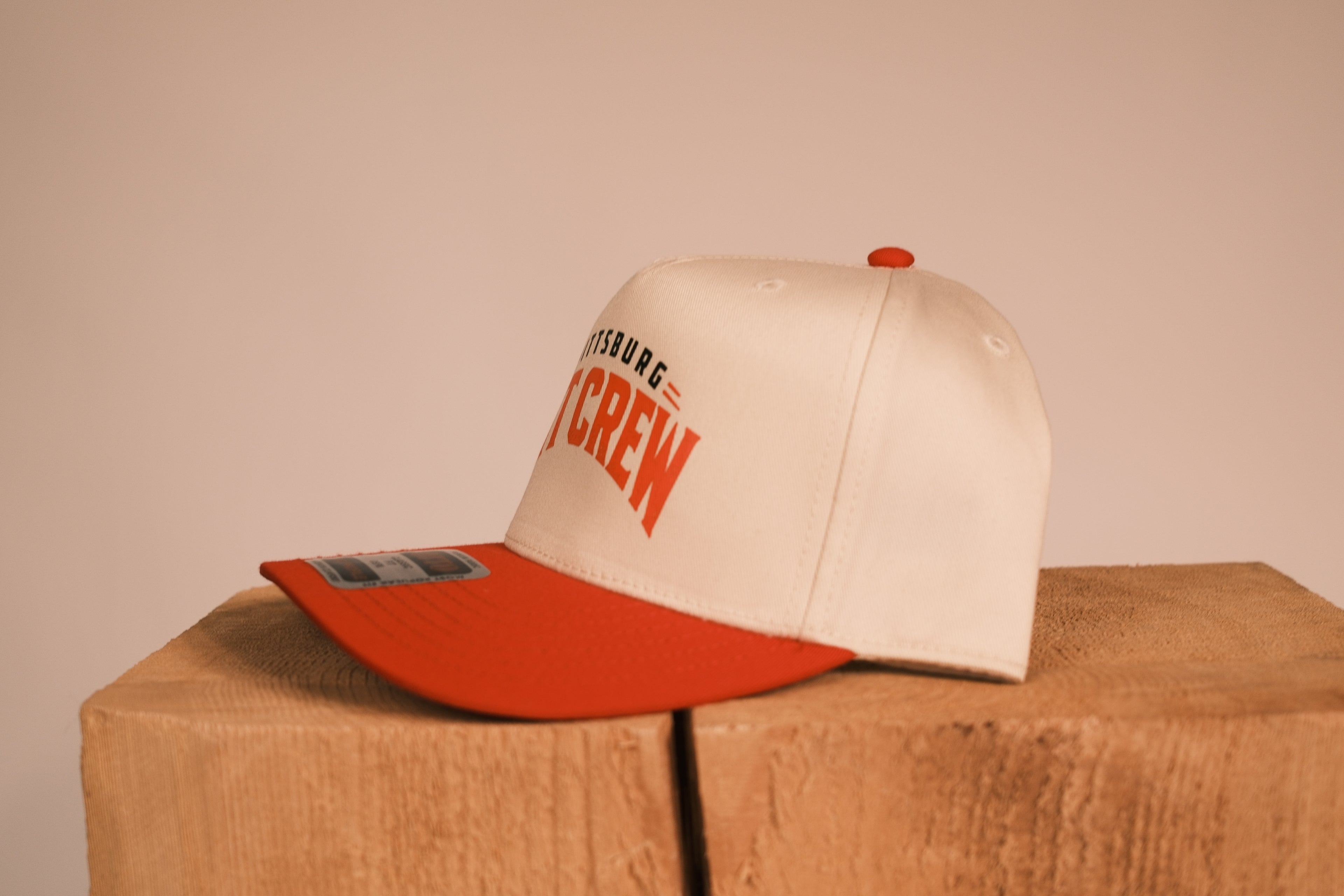 Red brim hat with Pittsburg Pit Crew on it