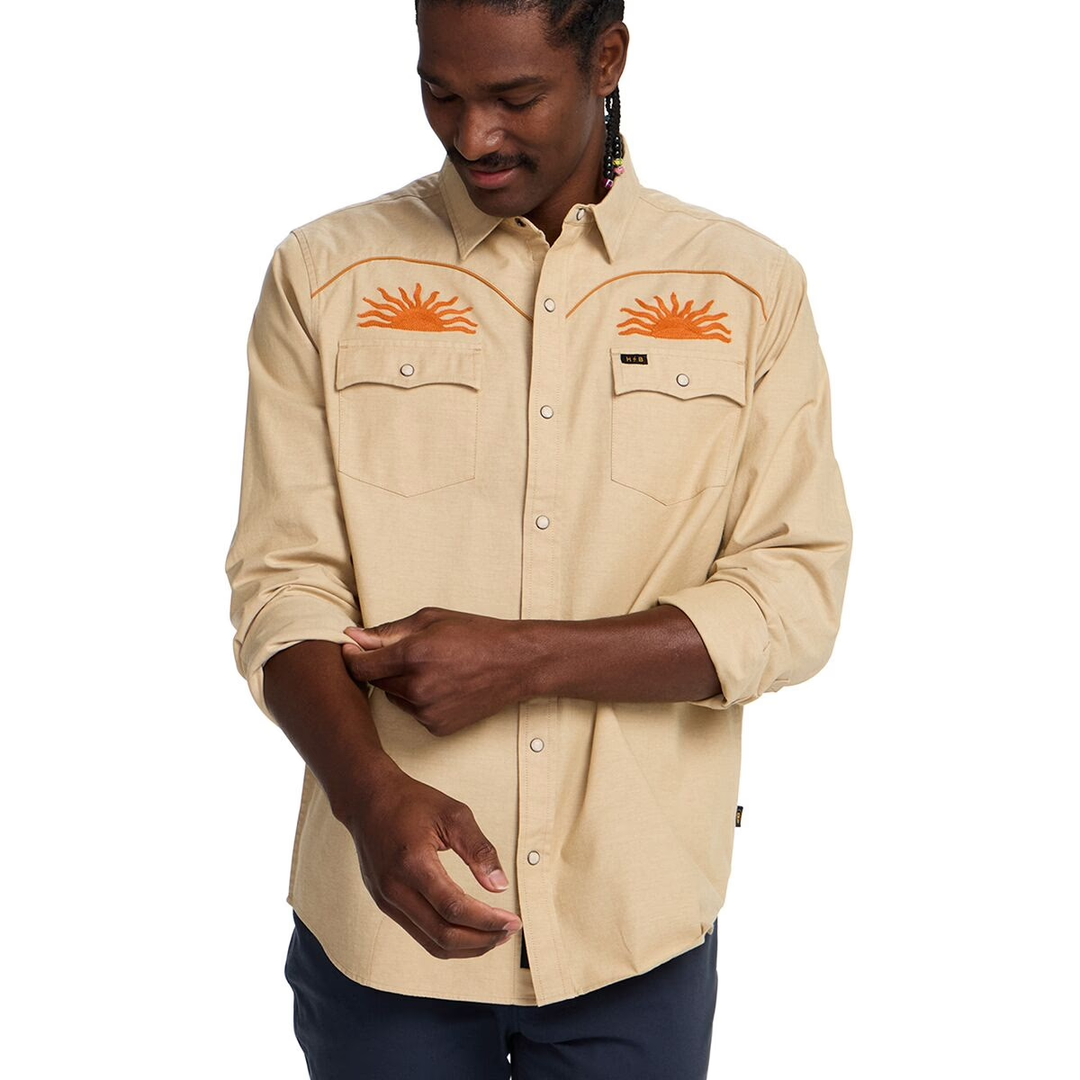Man wearing a beige shirt with orange embroidery on a white background
