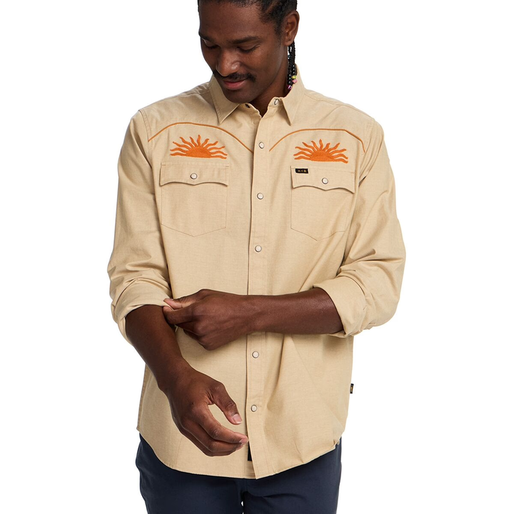 Man wearing a beige shirt with orange embroidery on a white background