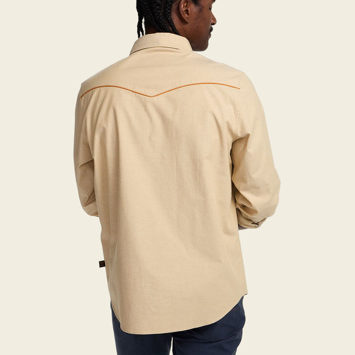 Beige shirt with orange stitching worn by a person on a white background