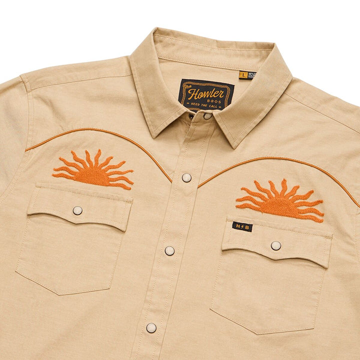 Beige shirt with orange sun designs on the chest pockets, featuring Howler Brothers label.