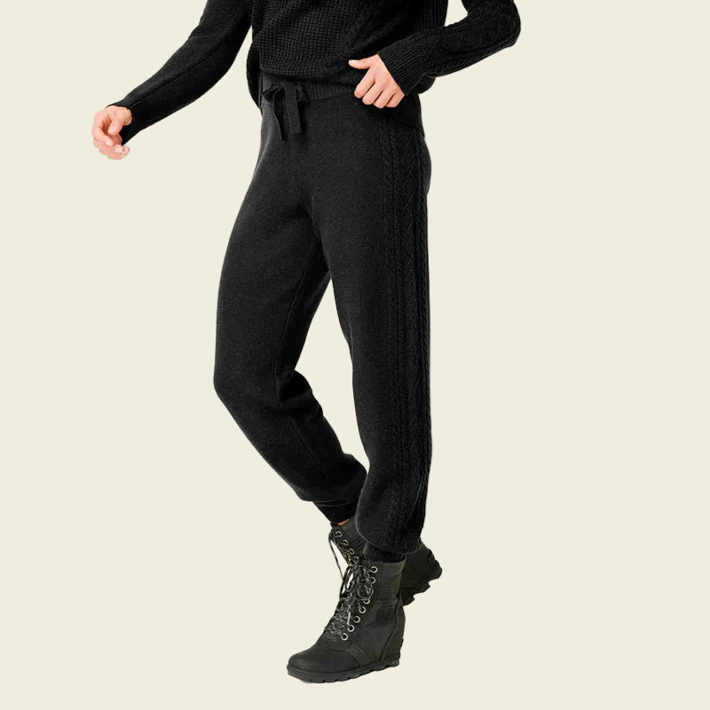 Person wearing black pants and boots on a white background