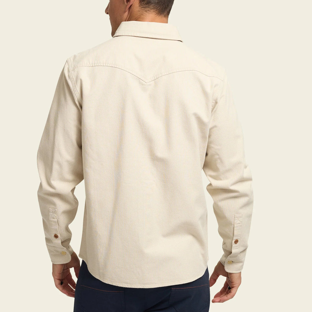 Man wearing a beige long-sleeve shirt on a plain background