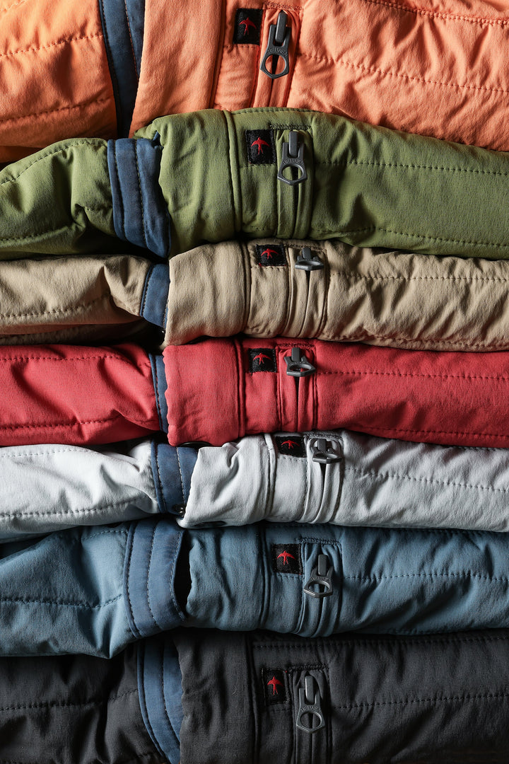 Stack of colorful jackets in various shades including green, red, blue, and gray.