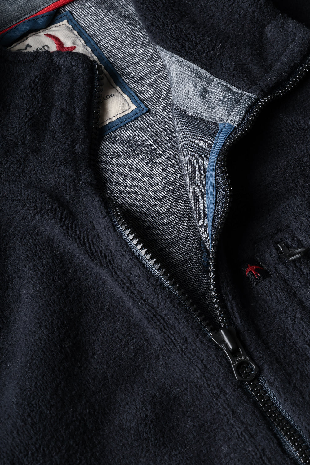 Close-up of a dark blue fleece jacket with a zipper and inner lining.