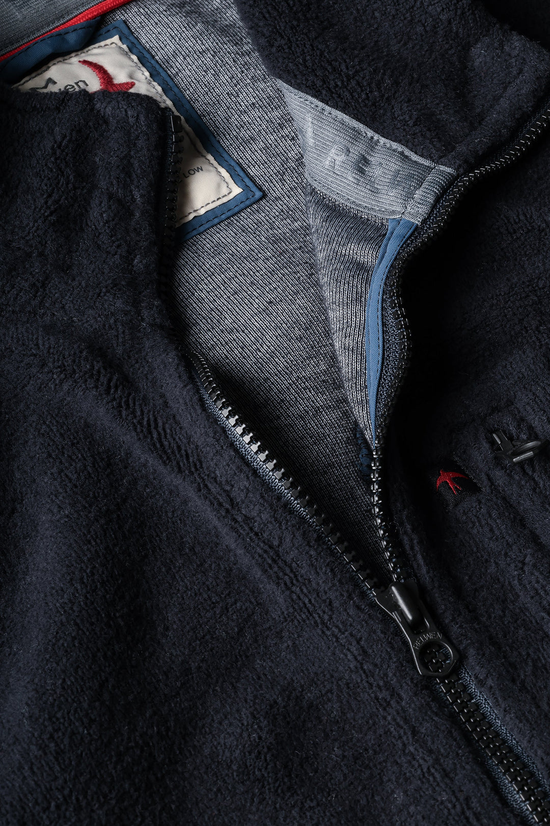 Close-up of a dark blue fleece jacket with a zipper and inner lining.